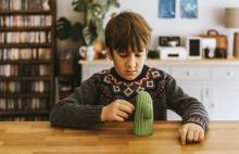 Child playing with a cactus toy